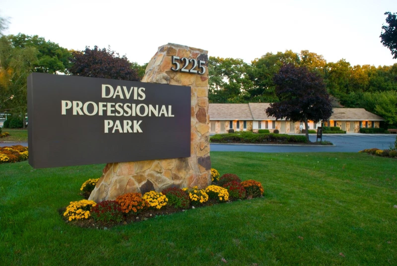 Davis Professional Park sign with stone base amidst landscaped greenery.
